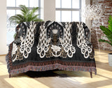 Piya Peacock Cotton Blend Blanket Throw in Black, draped over a chair