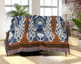 Piya Peacock Cotton Blend Blanket Throw in Burnt Orange, draped over a chair