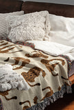Ren Leopard Cotton Blend Blanket Throw in Orange and Burnt Orange, on a bed