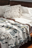 Ren Leopard Cotton Blend Blanket Throw in Gray and Off-White, on a bed