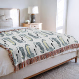 Ren Leopard Cotton Blend Blanket Throw in Gray and Off-White, draped over a chair