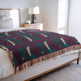 Ren Leopard Cotton Blend Blanket Throw in Purple and Teal, draped over a chair