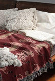 Ren Leopard Cotton Blend Blanket Throw in Red and Pink, on a bed