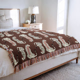 Ren Leopard Cotton Blend Blanket Throw in Rust Brown and Off-White, draped over a chair
