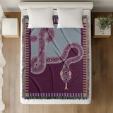 Sami Snake Cotton Blend Blanket Throw in Purple and Blue, on a bed