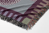Sami Snake Cotton Blend Blanket Throw in Purple and Blue, draped over a chair