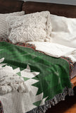Shako Southwestern Cotton Blend Blanket Throw in Green and Off-White, draped over a chair