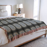 Speck Cotton Blend Blanket Throw in Blue, on a bed