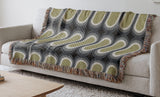 Speck Cotton Blend Blanket Throw in Chartreuse, draped over a chair