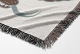 Spiga Snake Cotton Blend Blanket Throw in Burnt Orange, draped over a chair