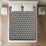 Stella Cotton Blend Blanket Throw in Gray and Off-White, on a bed