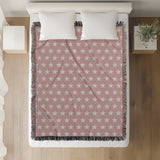 Stella Cotton Blend Blanket Throw in Pink and Off-White, on a bed
