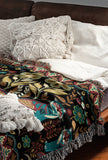 Tia Folksy Tiger Cotton Blend Blanket Throw in Black, Teal, Brown and Green, on a bed
