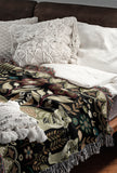 Tia Folksy Tiger Cotton Blend Blanket Throw in Black, Green, Red and Teal, on a bed