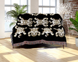 Usha Tibetan Tiger Cotton Blend Blanket Throw in Black and Off-White, draped over a chair