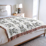 Usha Tibetan Tiger Cotton Blend Blanket Throw in Off-White, on a bed