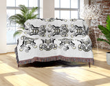 Usha Tibetan Tiger Cotton Blend Blanket Throw in Off-White, draped over a chair