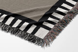 Vanjo Snake Cotton Blend Blanket Throw in Beige, Black and Off-White, draped over a chair
