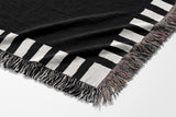 Vanjo Snake Cotton Blend Blanket Throw in Black and Off-White, draped over a chair