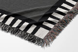 Vanjo Snake Cotton Blend Blanket Throw in Gray, Black and Off-White, draped over a chair