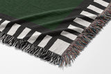 Vanjo Snake Cotton Blend Blanket Throw in Green, Black and Off-White, draped over a chair