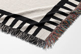 Vanjo Snake Cotton Blend Blanket Throw in Off-White, draped over a chair
