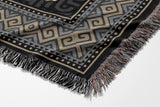 Voha Tibetan Tiger Cotton Blend Blanket Throw in Black, Brown and Gray, draped over a chair