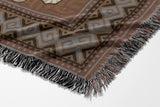 Voha Tibetan Tiger Cotton Blend Blanket Throw in Orange, Beige and Burnt Orange, draped over a chair