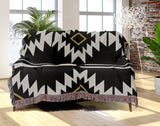 Wapi Southwestern Cotton Blend Blanket Throw in Black and Off-White, draped over a chair