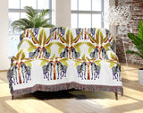 Xavier Zebra Cotton Blend Blanket Throw in Black, Yellow Green and Off-White, draped over a chair