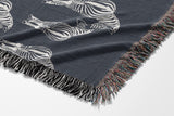 Ziggy Zebra Cotton Blend Blanket Throw in Blue Gray and Off-White, draped over a chair