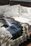 Zio Southwestern Cotton Blend Blanket Throw in Blue, Off-White and Dull Gold, draped over a chair