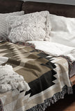 Zio Southwestern Cotton Blend Blanket Throw in Brown, Off-White and Dull Gold, draped over a chair