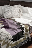 Zio Southwestern Cotton Blend Blanket Throw in Purple, Off-White and Dull Gold, draped over a chair