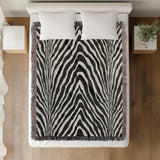 Zoe Animal Print Cotton Blend Blanket Throw in Black, on a bed