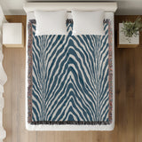 Zoe Animal Print Cotton Blend Blanket Throw in Blue, on a bed