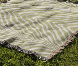 Zoe Animal Print Cotton Blend Blanket Throw in Chartreuse, draped over a chair