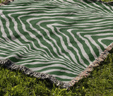 Zoe Animal Print Cotton Blend Blanket Throw in Green, draped over a chair