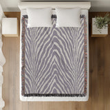 Zoe Animal Print Cotton Blend Blanket Throw in Periwinkle, on a bed
