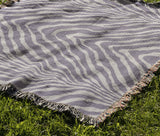 Zoe Animal Print Cotton Blend Blanket Throw in Periwinkle, draped over a chair