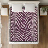 Zoe Animal Print Cotton Blend Blanket Throw in Purple, on a bed