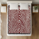 Zoe Animal Print Cotton Blend Blanket Throw in Red, on a bed