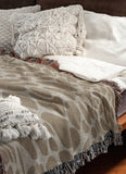 Zuma Animal Print Cotton Blend Blanket Throw in Beige, draped over a chair