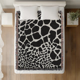 Zuma Animal Print Cotton Blend Blanket Throw in Black, on a bed