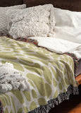 Zuma Animal Print Cotton Blend Blanket Throw in Chartreuse, draped over a chair