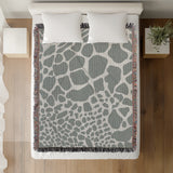 Zuma Animal Print Cotton Blend Blanket Throw in Gray, on a bed