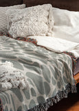 Zuma Animal Print Cotton Blend Blanket Throw in Gray, draped over a chair