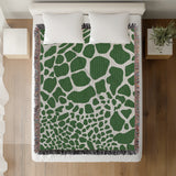 Zuma Animal Print Cotton Blend Blanket Throw in Green, on a bed