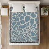 Zuma Animal Print Cotton Blend Blanket Throw in Light Blue, on a bed