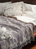 Zuma Animal Print Cotton Blend Blanket Throw in Periwinkle, draped over a chair